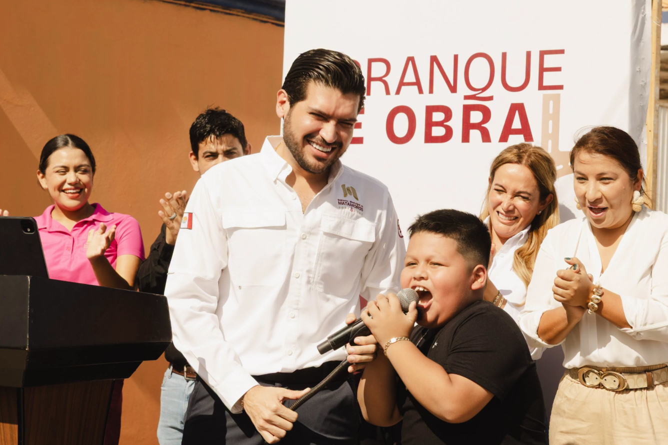 Un niño canta acompañado por integrantes de la comunidad de Matamoros