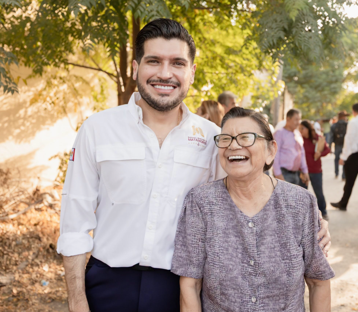 Una mujer y un representante de Matamoros sonríen durante un encuentro comunitario